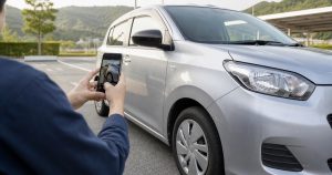 車の気になる箇所を全体と近景に分けてスマートフォンで撮影する人